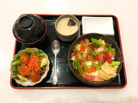 Salmon roe and salad with japanese ingredient on rice on table with set.の写真素材