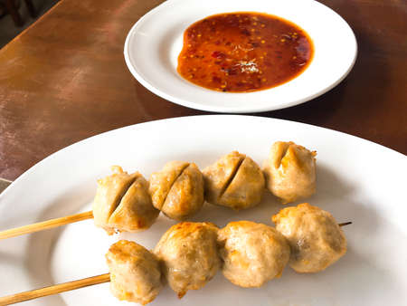 Grill pork ball pour with sweet spicy sauce on wooden table  background.の写真素材