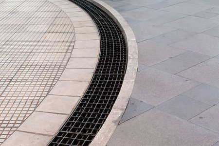 Metal drain shape circular or manhole cover hole system on road side in urban city, Japan.の写真素材