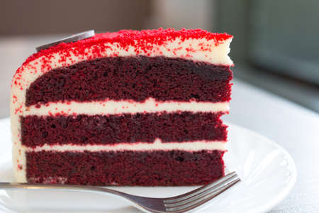 Tasty Red Velvet cake with fork on table at cafe.の写真素材