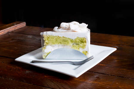 Tasty coconut cake with fork on white plate.の写真素材