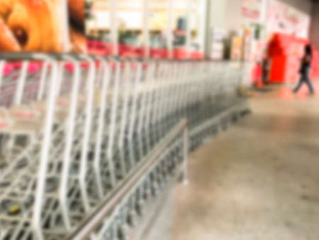 Blur image pushing a shopping cart in the supermarket.