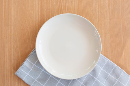 White plates with grid pattern table cloths top view on table wooden.の写真素材