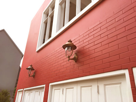 Exterior old orange brick wall surface texture background with window and vintage lamp. Design element.の写真素材