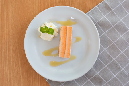 Delicious piece of passion fruit cake  with passion fruit sauce on white plates, top view on table...