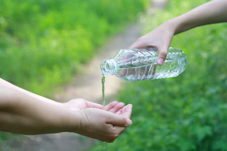 Bottled water pouringg on hands.の写真素材