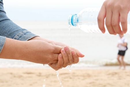 Woman washing hand using bottled water