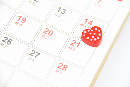 Red heart sign laying on calendar pageの写真素材