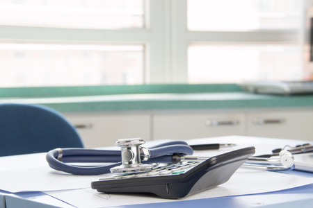 Close-up of stethoscope and calculatorの写真素材