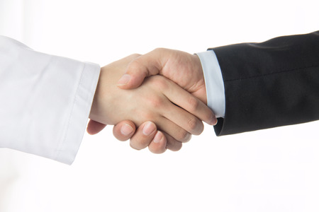 Doctor and businessman shaking handsの写真素材