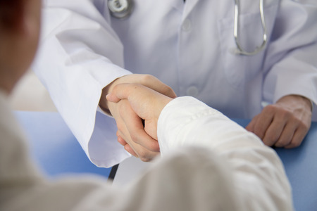 Doctor and businessman shaking handsの写真素材