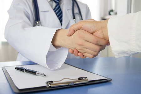 Doctor and businessman shaking hands