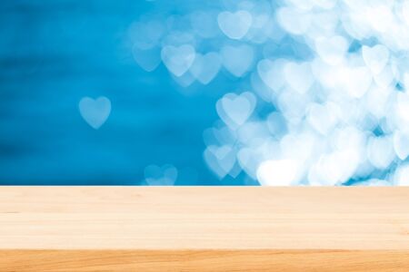 Empty wooden table over bokeh heart-shaped background