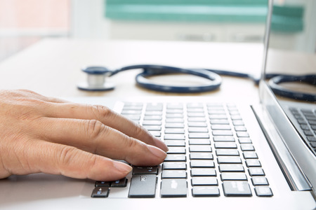 Close up of doctor's hand at computer typing