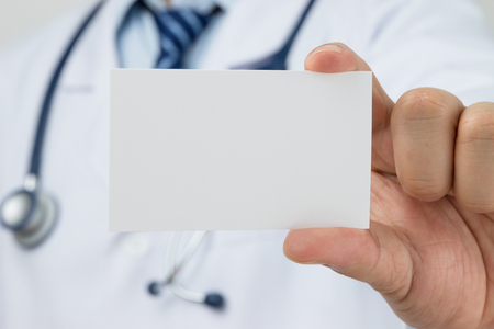 Doctors hand holding a business cardの写真素材