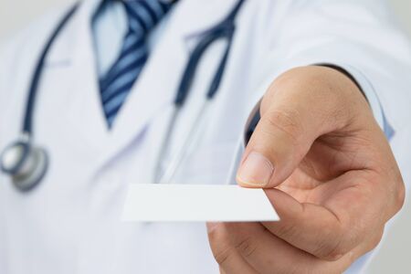 Doctors hand holding a business cardの写真素材