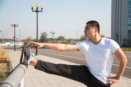 Young Asian man doing stretchingの写真素材