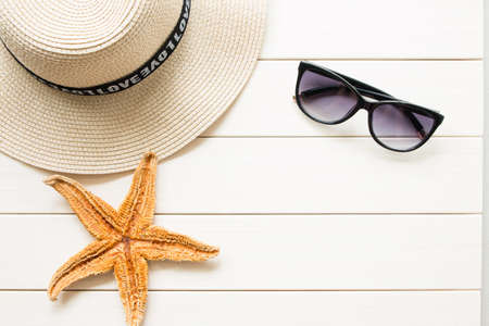 Straw hat and sunglasses on wooden backgroundの写真素材