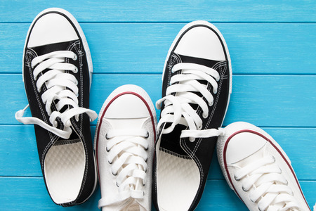 Two pairs of canvas shoes on a blue woodenの写真素材