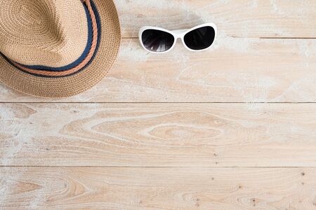 Straw hat and sunglasses on woodの写真素材