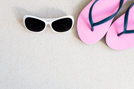 Sunglasses and slippers on the beachの写真素材