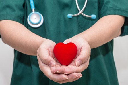 Doctor's hands holding a heart shapeの写真素材