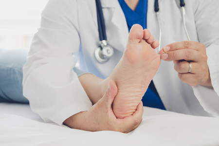 Doctor giving a patient foot treatmentの写真素材