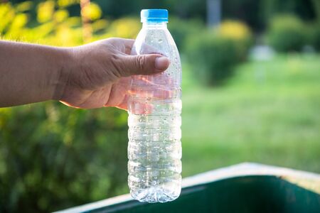 Throw the plastic bottle into the trash canの写真素材