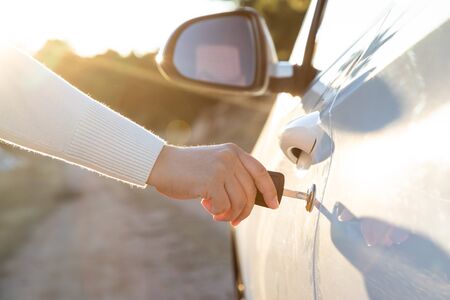Woman takes the key to drive the door of the carの写真素材