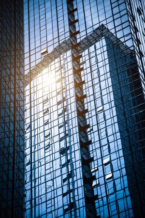 Modern glass building reflecting skyscrapersの写真素材