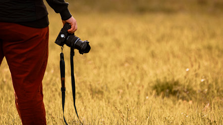 Photographer with a camera in a field. Selective focus.