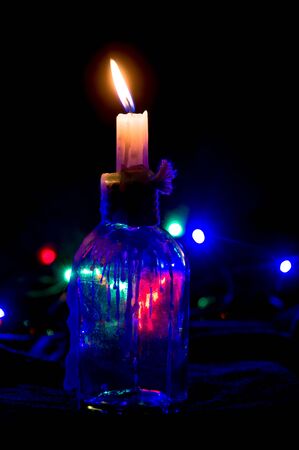 Decorative transparent candle holder with lighted candle inside.の写真素材