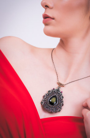 Close up of beautiful woman wearing diamond necklace with large emerald stoneの写真素材