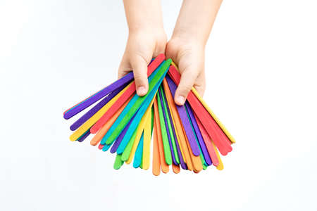 Child's hand holding ice cream on stick. Ice cream desire. Isolated on white background.の写真素材