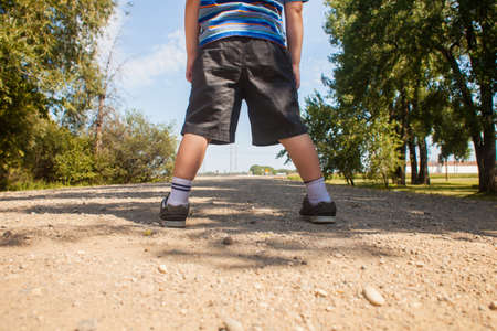 Toddler stands on gravel roadの写真素材