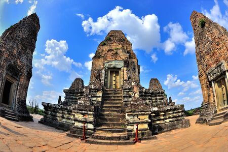red ancient angkor temple against blue skyの写真素材