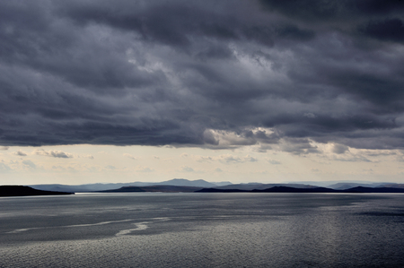 dark low stormy clouds above the sea, ripples on the seaの写真素材