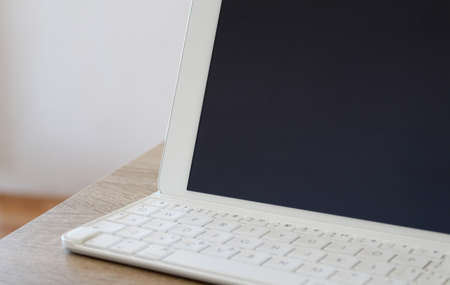 White tablet with keyboard on the table