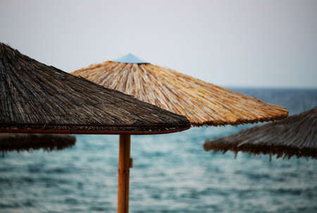 Wooden sun parasols at beach by the seaの写真素材