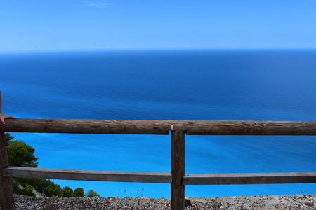 a wooden fence with a blue sea in the backgroundの写真素材