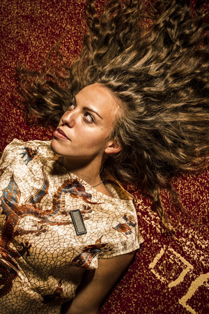 Brunette girl laying on the florの写真素材