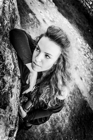 A girl leaning against the rockの写真素材