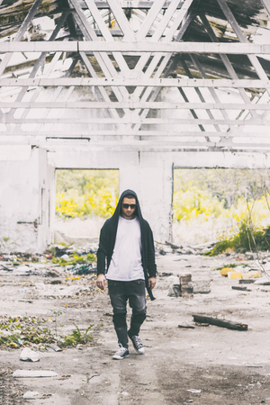 male portrait walking with a hoodie and sunglassesの写真素材