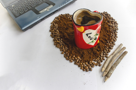 Cup of coffee on the coffee bean with pencil and notebookの写真素材