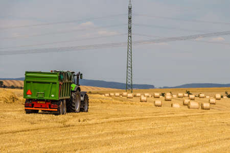 Tractor harvester working in wheat field in summer timeのeditorial素材