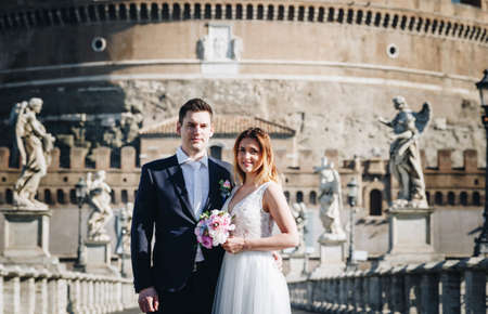 Bride and groom wedding poses in front of Castel Sant'Angelo, Rome, Italyの写真素材
