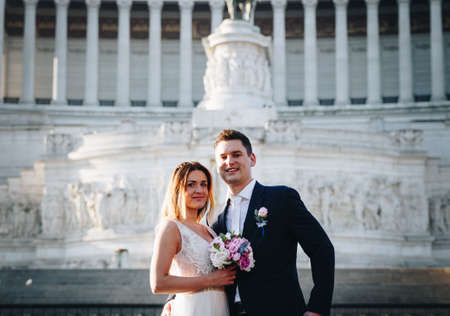 Bride and groom wedding poses in front of Altar of the Fatherland (Altare della Patria), Rome, Italyの写真素材
