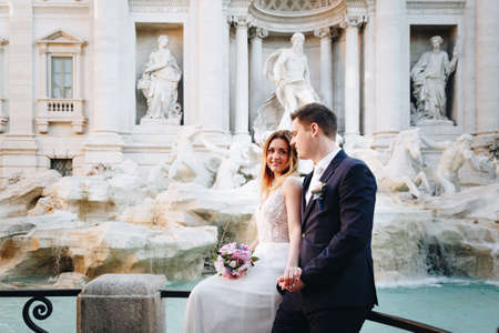 Bride and groom wedding poses in front of Trevi Fountain (Fontana di Trevi), Rome, Italyの写真素材
