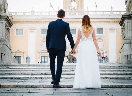 Bride and groom wedding poses in front of Capitol Hill (Campidoglio), Rome, Italyの写真素材