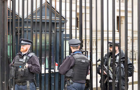 London, UK - 1st April, 2017: Police officers protecting the gate of Downing street in London, the residence of the prime minister.のeditorial素材